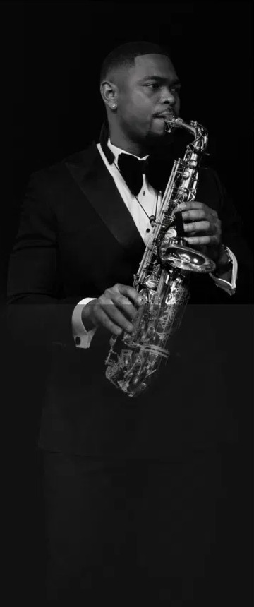 Will Pefok in a tuxedo holding his saxophone